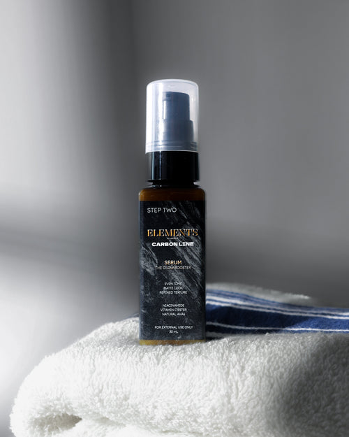 Bottle of 'Elemente Carbon Line' hair product on a white towel with a gray background