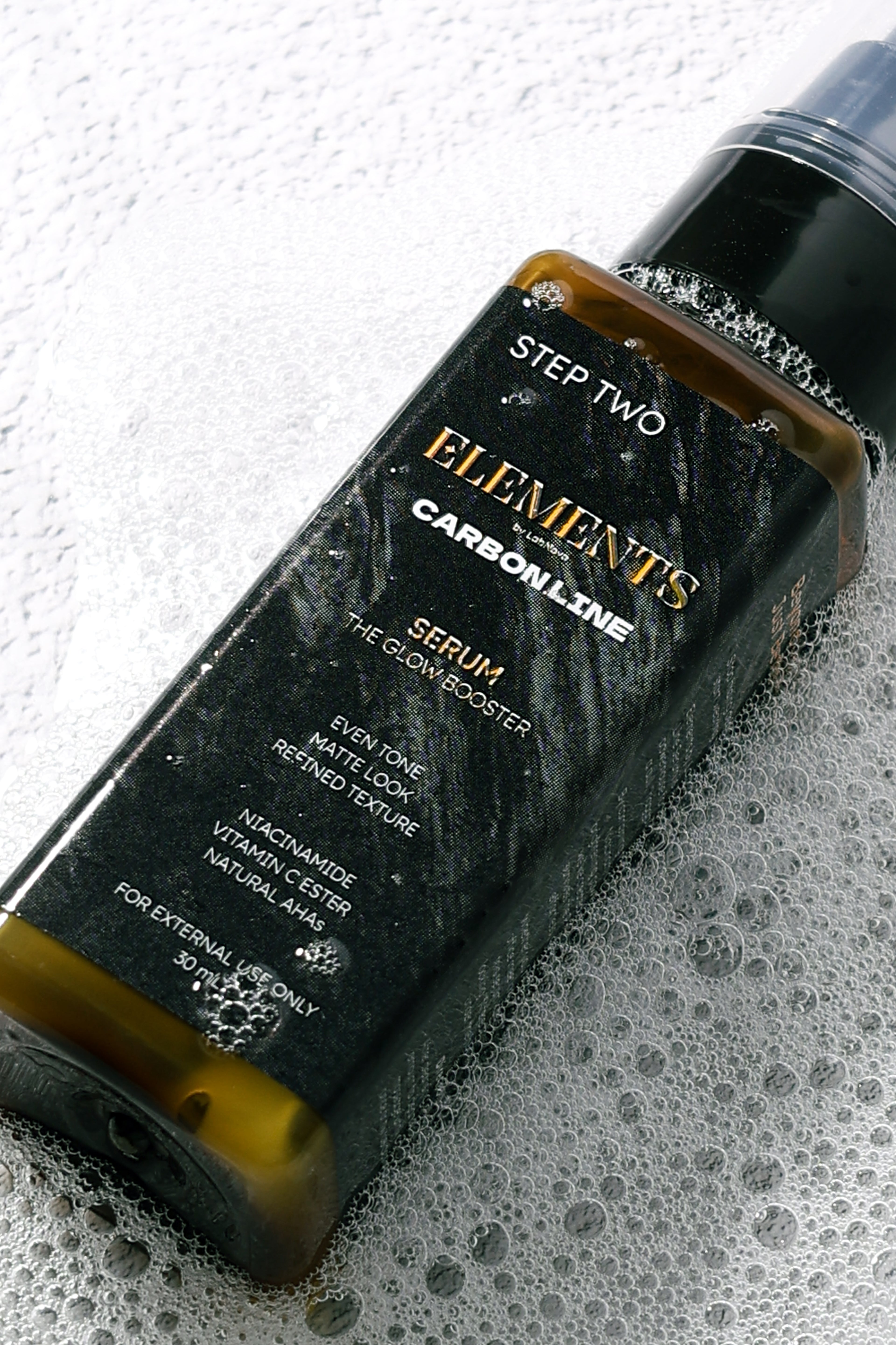 Bottle of 'Elements' serum on a textured surface