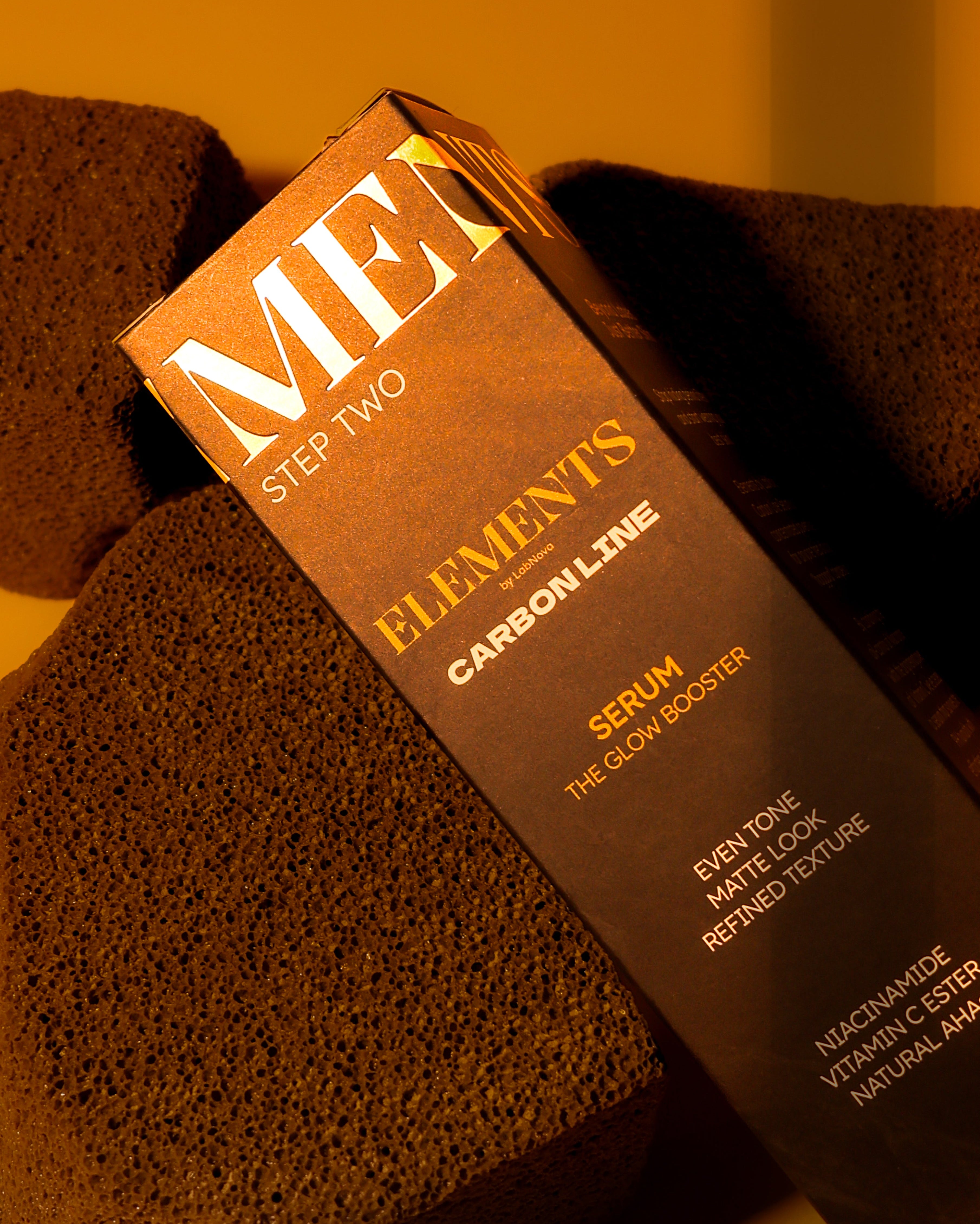 Skincare serum packaging with 'Men' branding on a textured brown background