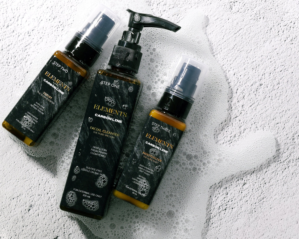 Three bottles of 'Elements' skincare products on a textured white surface.