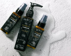 Three bottles of 'Elements' skincare products on a textured white surface.